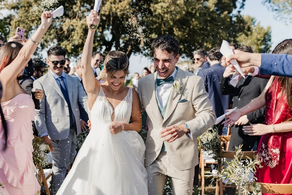 Los novios salen entre el arroz que les lanzan los invitados